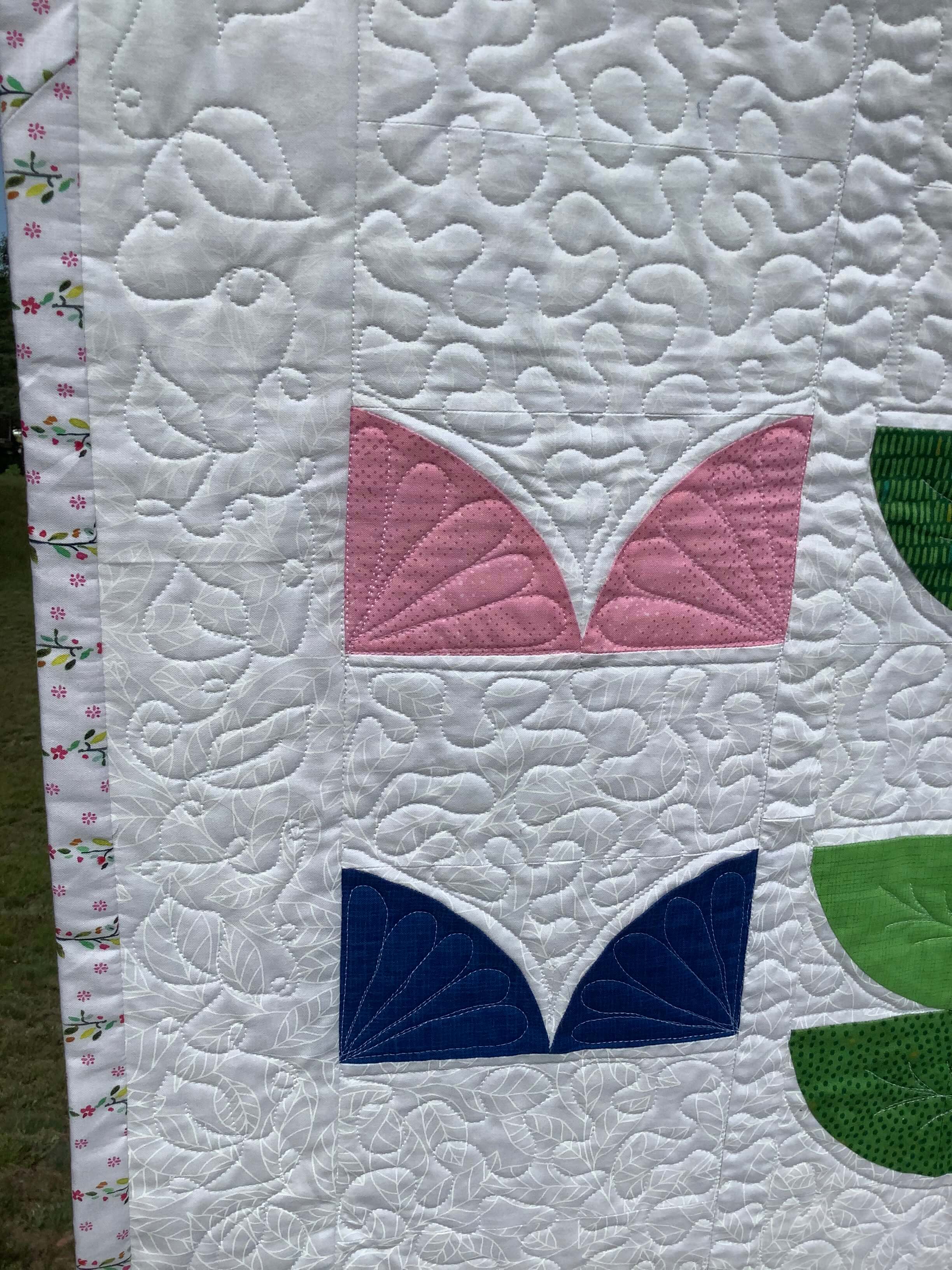 closeup shot of a quilt with bird song pattern by Stich and a Round